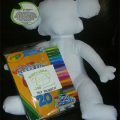 A white teddy bear with a package of crayons.