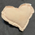 A heart shaped pillow is on the table.